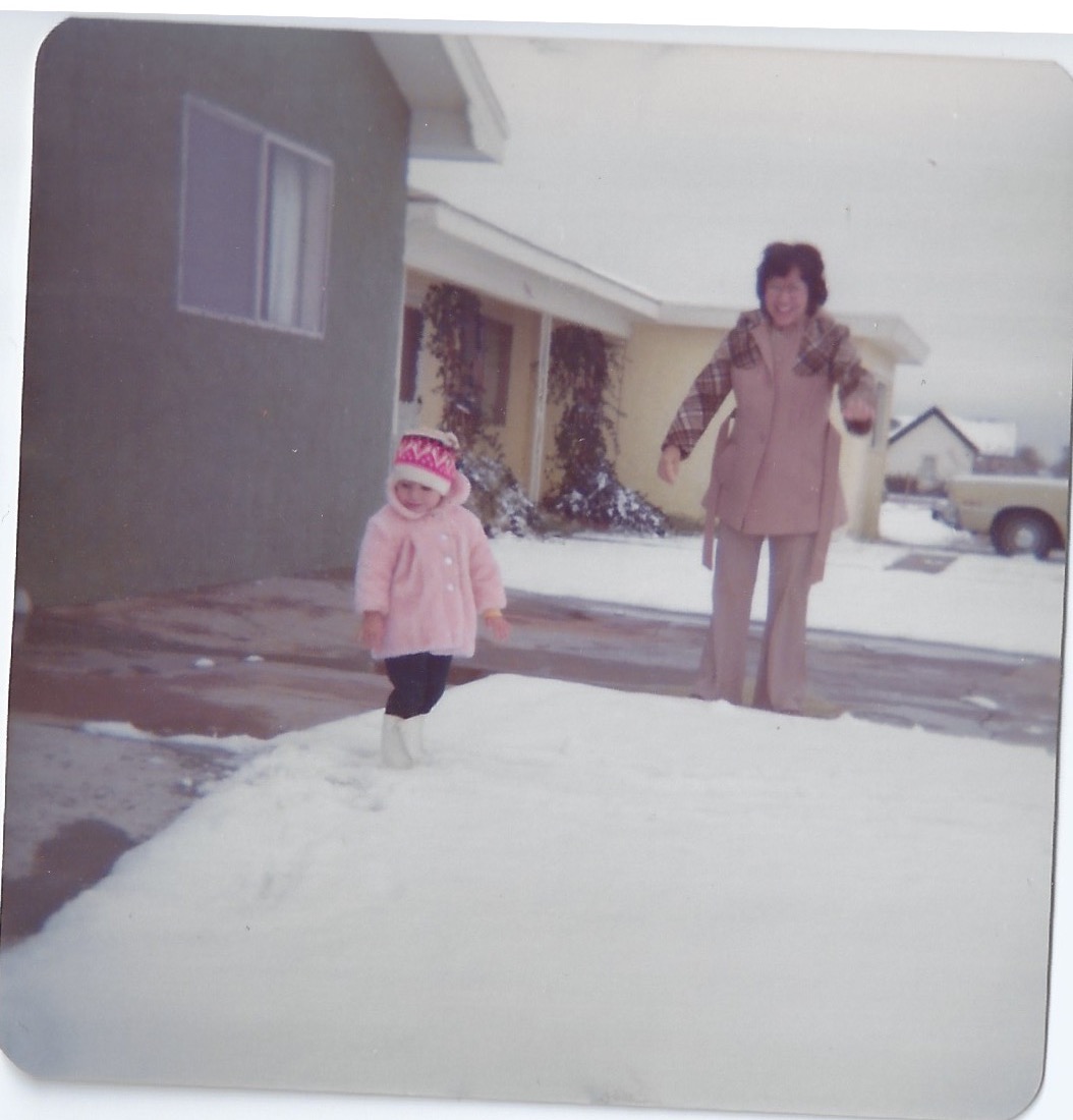 older sister in funky winter hat with mom